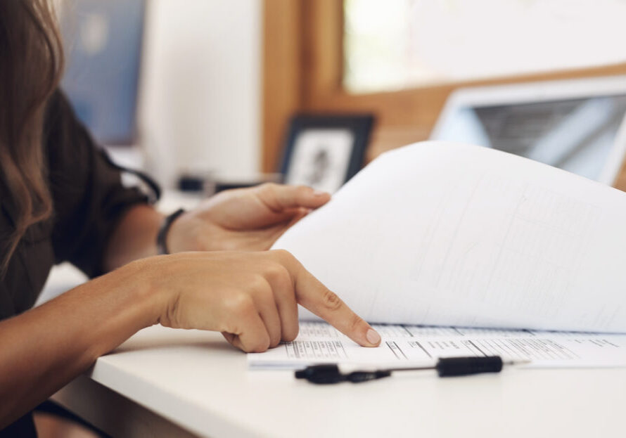 Closeup shot of an unrecognisable businesswoman going through paperwork in an office.