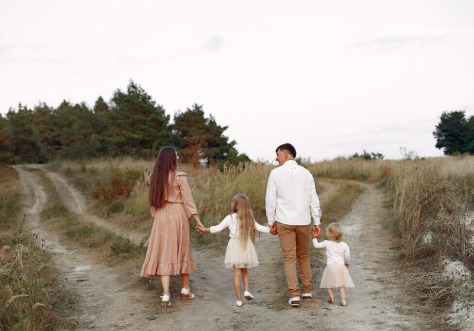 Family with cute little chirt. Father in a white shirt. Lady in apink dress