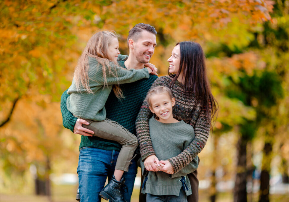 Portrait of happy family of four in autumn day