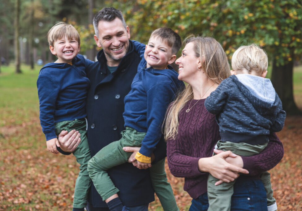 Happy family portrait together at park - Candid beautiful young family with children enjoying time outdoors - Lifestyle and family concepts