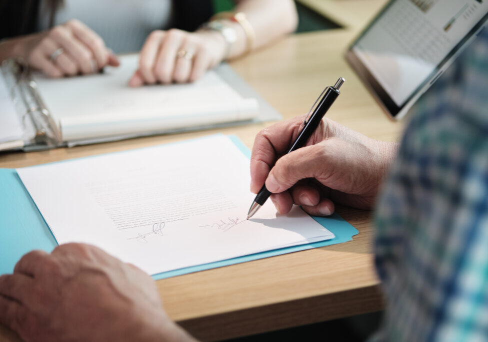 Manager at work as financial consultant talking to elderly people. Senior man meeting health insurance broker or retirement plan agent for signature on agreement