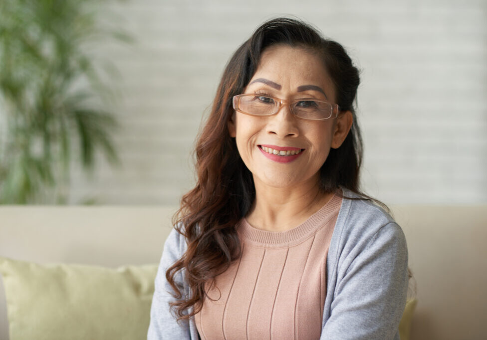 Portrait of Asian smiling mature woman sitting at home