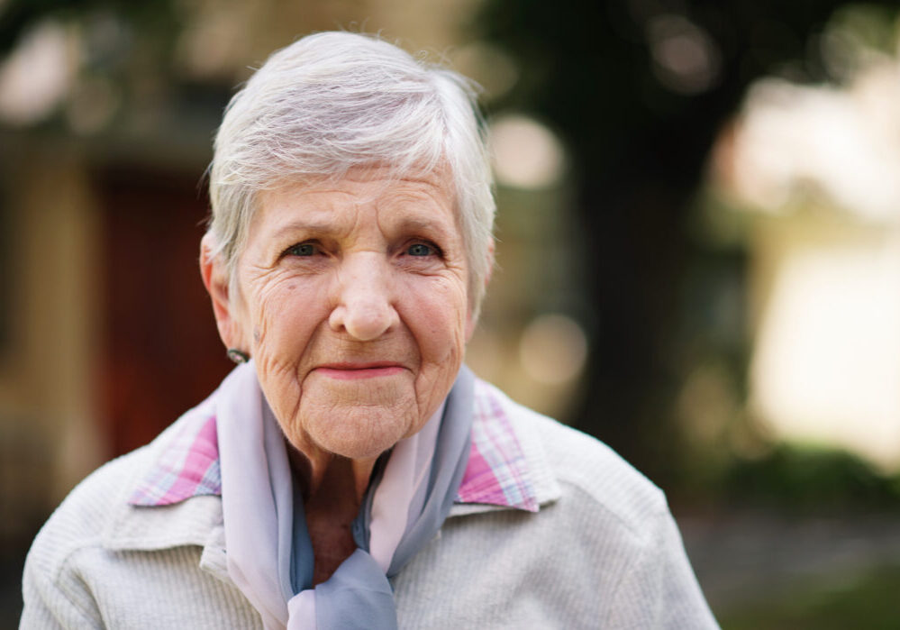 Portrait of elderly woman smiling happy enjoying day in park.