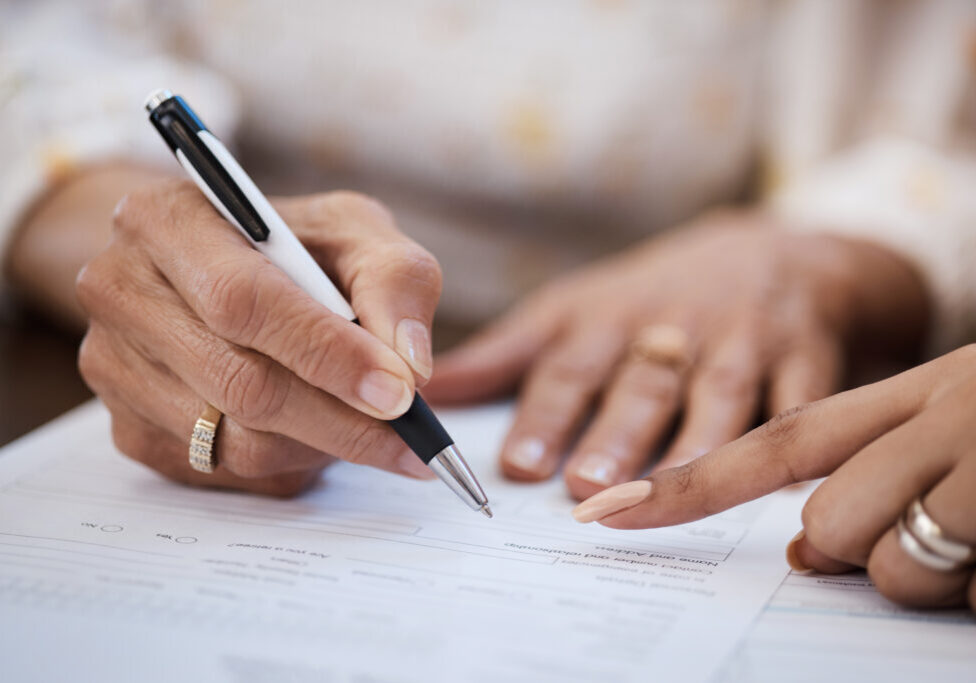 Shot of a woman going over paperwork with her elderly mother at home.