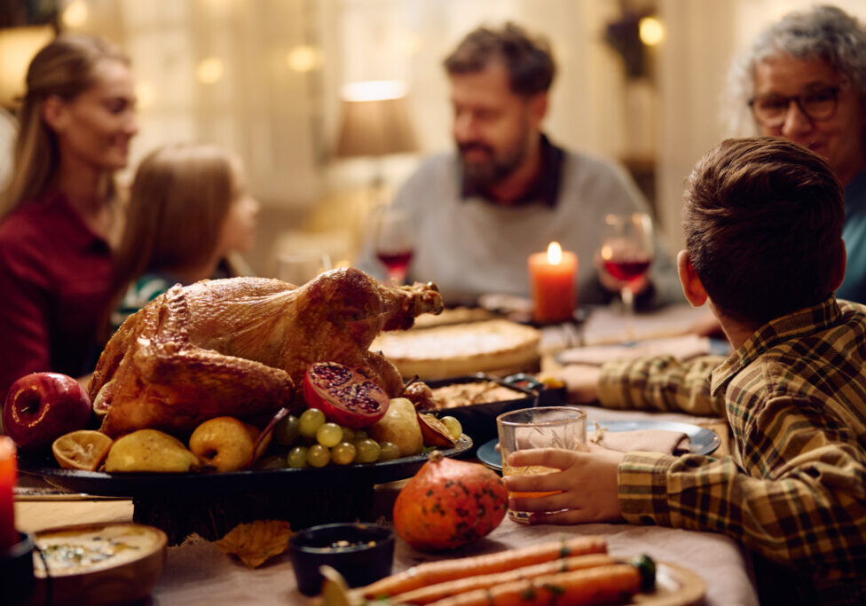 Roast turkey on dining table during family meal on Thanksgiving.