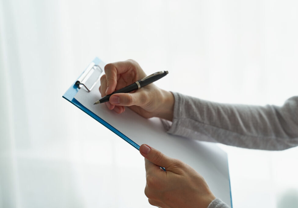 Woman holding clipboard, concept of office work or studying student side view closeup person writing on clipboard with pen, secretary or inspector idea, formal clothes